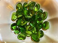 Group of green glass stones in bowl