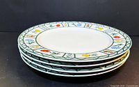 Stack of four plates showing floral border design
