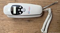 Top view showing GE slimline phone base with caller ID screen and handset cord