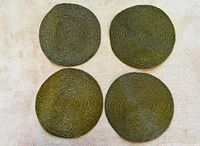 Four gold beaded round placemats laid flat
