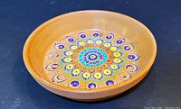 Oblique view of terracotta dish showing painted mandala interior