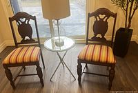 Pair of mahogany chairs beside side table, front view