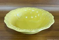 Top angled view of entire yellow Bordallo bowl showing relief rim and interior