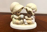 Front view of figurine showing two children having tea