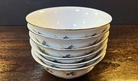 Stack of six matching bowls showing exterior pattern and gold rims