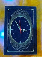 Front view of rectangular string art clock showing wire pattern and hands