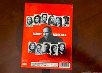 Back of red outer box showing cast photos and tagline
