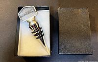 Stopper in open box showing topper and rubber rings