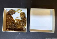 Two brown and gold beaded tassel pendants in box