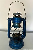 Full view of blue metal kerosene lantern front