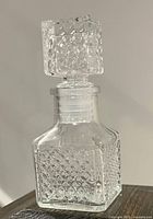 Front view of square pressed glass cologne bottle with stopper inserted