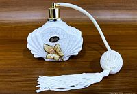 Front view of Berger Italian ceramic seashell perfume atomizer bottle showing crackle glaze, leaf motif and atomizer hardware