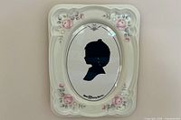 Front view of porcelain frame showing floral design and oval opening