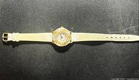Full view of watch laid flat showing entire band and face