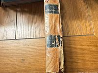 Spine view showing torn leather and partial labels