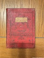 Front cover of red cloth book titled My King showing decorative embossing