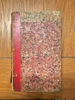 Front cover showing red leather spine and marbled boards