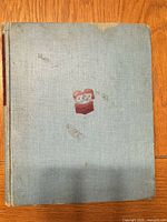 Front cover showing cloth boards, red emblem, wear