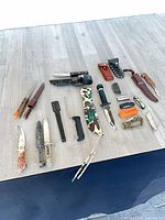 Full layout of assorted knives, sheaths, arrows on table