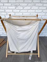 Front view of wooden stand and canvas hamper bag