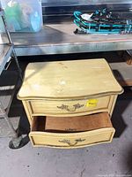 Front view of Dixie DuBarry two-drawer nightstand showing overall design and open lower drawer