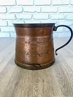 Front view of copper and brass pitcher with handle