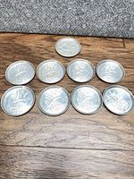 All nine hammered aluminum coasters arranged to show designs