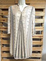 Full view of beaded dress hanging on mannequin, front facing