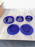 All nine cobalt blue Gibson glass pieces arranged on table