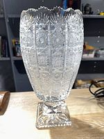 Full view of clear cut glass pedestal vase on square base