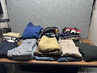 Full lot of folded men’s clothes on table