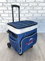 Front angle showing overall cooler, pull handle, wheels, front pocket logo