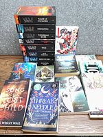 Overall lot showing Wilbur Smith stack and assorted other books