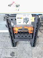 Folded WORX sawhorses with clamps visible