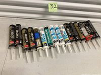 Row of approximately 16 caulk/sealant tubes
