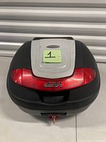 Top view of GIVI E340 Tech top box showing red smoked lens and grey lid panel