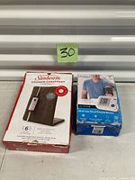 Boxed Sunbeam heating pad and LifeSource UA-767FAM blood pressure monitor