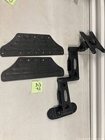 All components laid out: two attachment rails, dual arm segments, VESA plate and wall plate