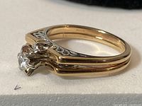 Side view of 14K gold ring showing diamond setting and double-band shank