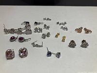 All fifteen earring pairs laid out on table