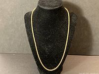 Full view of gold rope chain displayed on black bust
