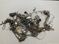 pile of assorted broken silver jewelry pieces