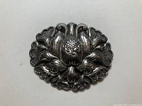 Front view of ornate 900 silver floral brooch