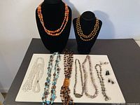 Full lot overview on table with necklaces on busts and additional items