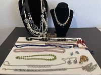 Full lot overview showing necklaces on busts and nineteen items on board