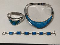 Overall view of collar necklace, cuff bracelet and link bracelet