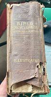 Spine view showing gilt title 'Bible Encyclopedia Illustrated' and severe leather spine damage