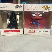 Front view of boxed Hallmark Darth Vader and Spider-Man ornaments