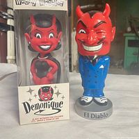 Front view of boxed Demonique bobble head and loose El Diablo figure