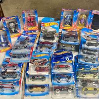 Overhead view of majority of Hot Wheels blister-pack cars spread on table